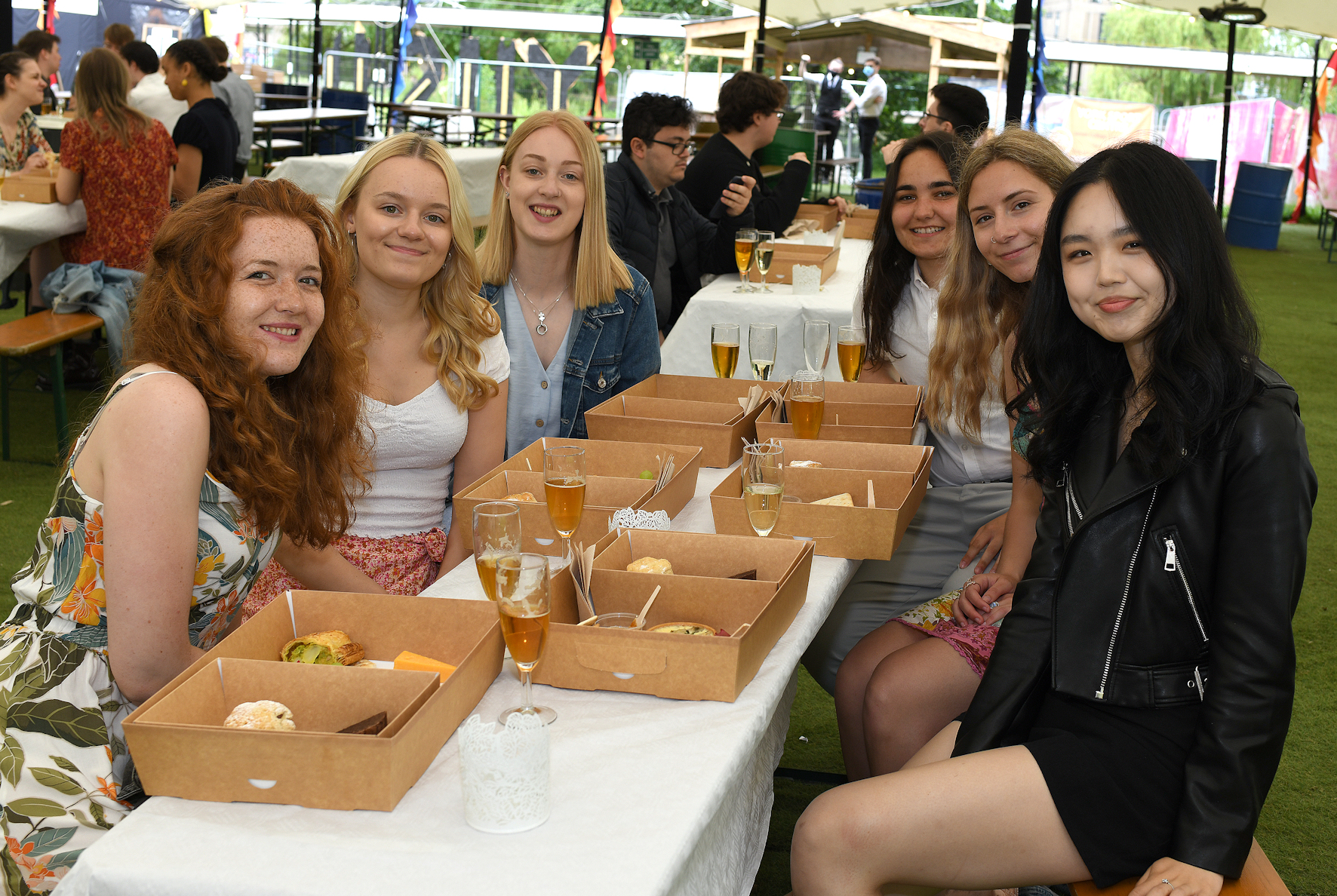 students sitting at a table with drinks and a picnic